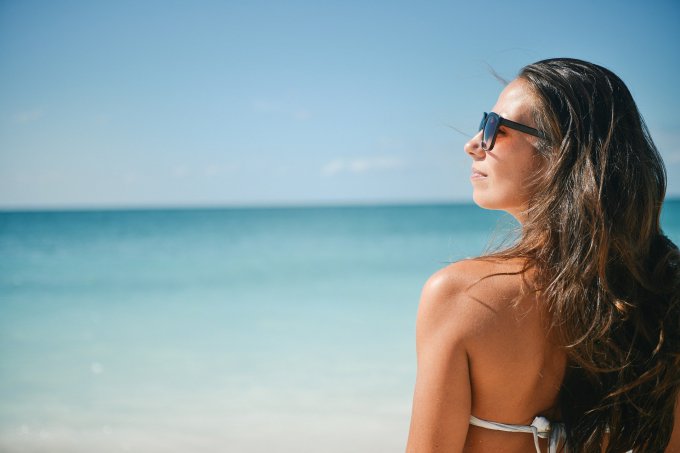 kobieta w okularach przeciwsłonecznych na plaży